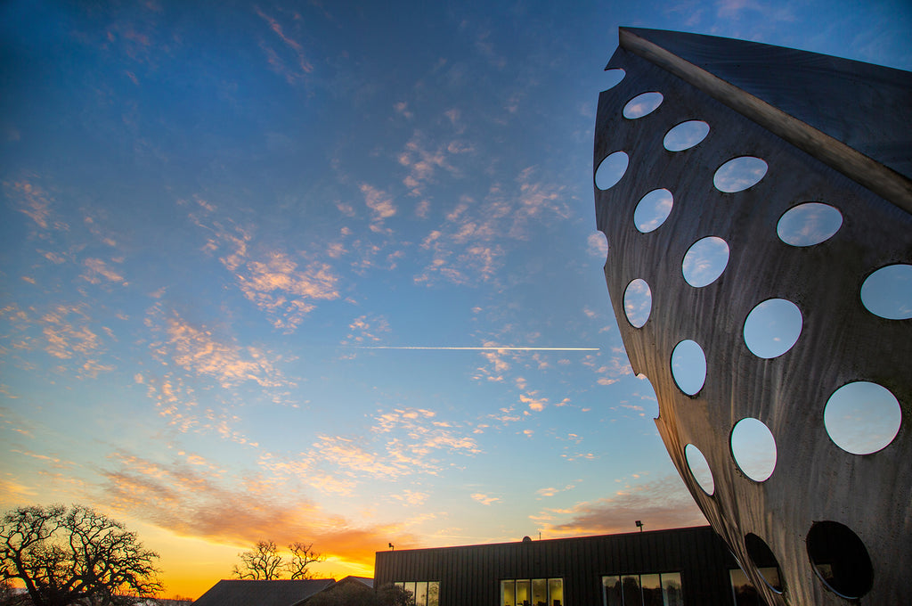 Hildon Office and silver sculpture against sunrising behind.