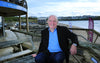Rick Stein smiling to camera, looking relaxed, sitting at outside table 